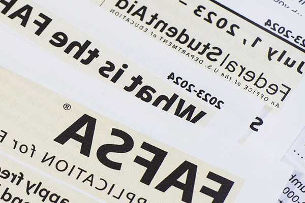 Close-up of printed documents related to the FAFSA (Free Application for Federal Student Aid) for the 2023-2024 academic year. The text highlights key phrases such as 'What is the FAFSA,' 'Federal Student Aid,' and application dates from July 1, 2023, to June 30, 2024.